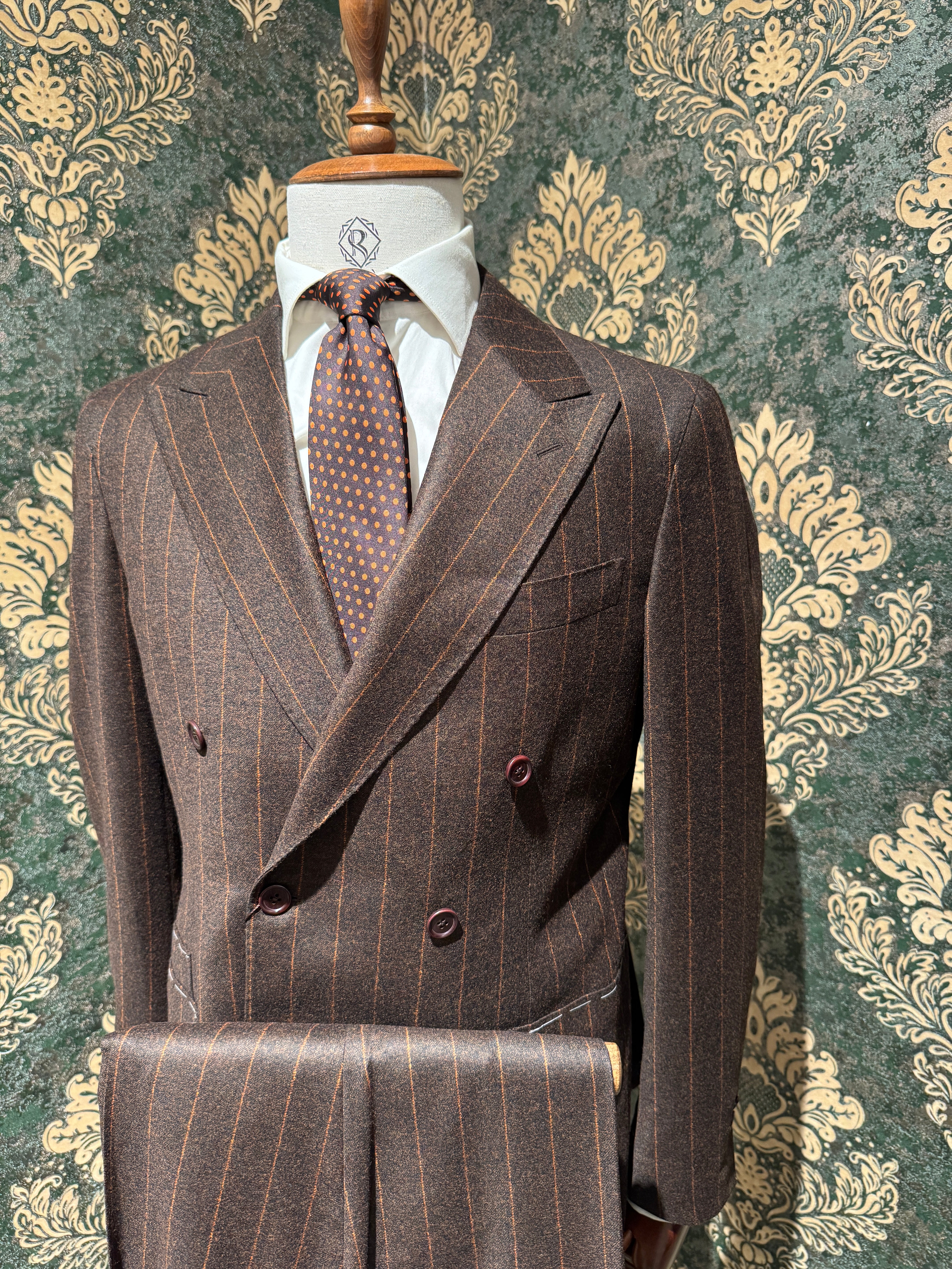 Zweireihiger brauner Nadelstreifenanzug mit orangefarbenen Streifen.