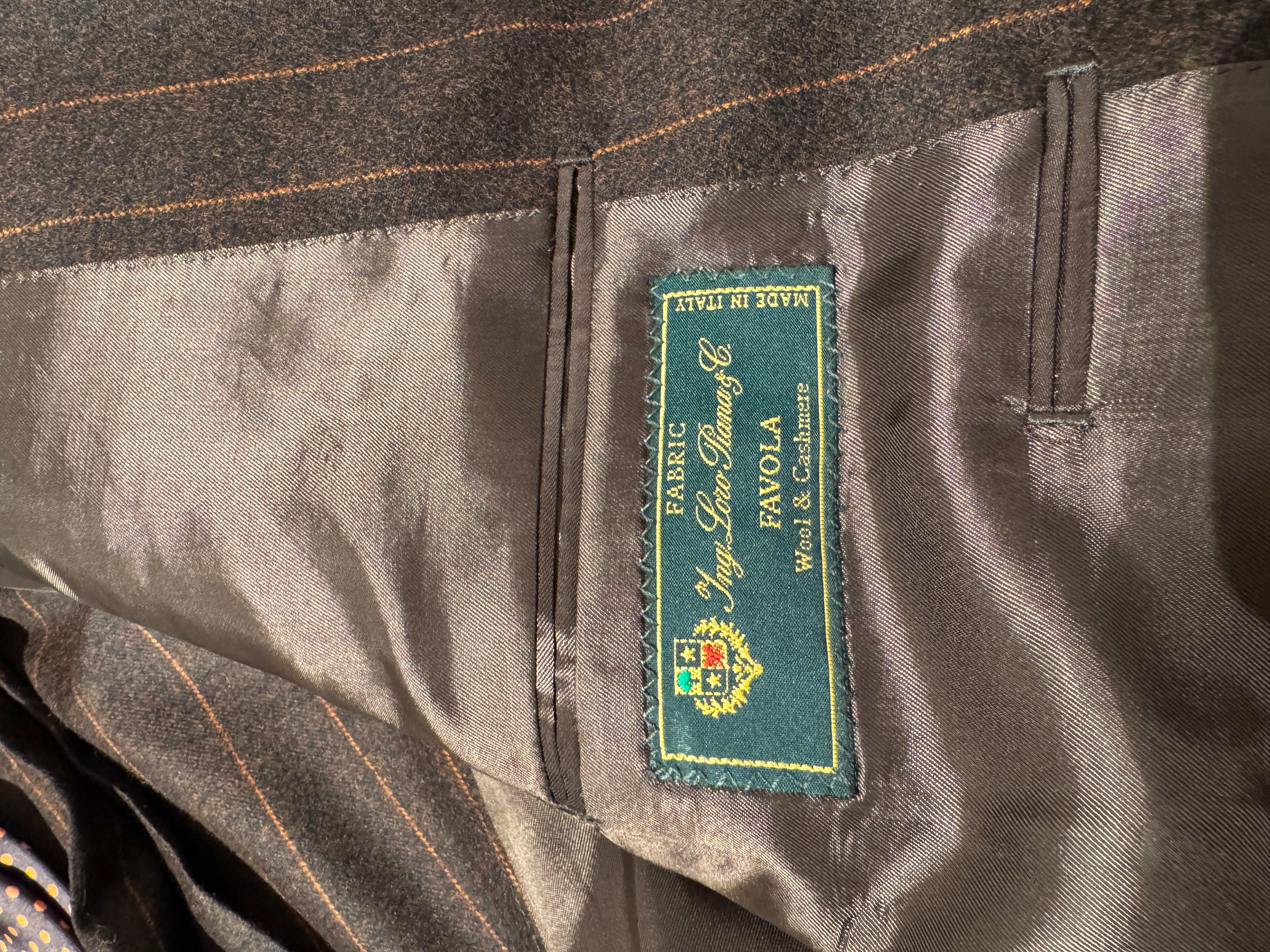 Zweireihiger brauner Nadelstreifenanzug mit orangefarbenen Streifen.