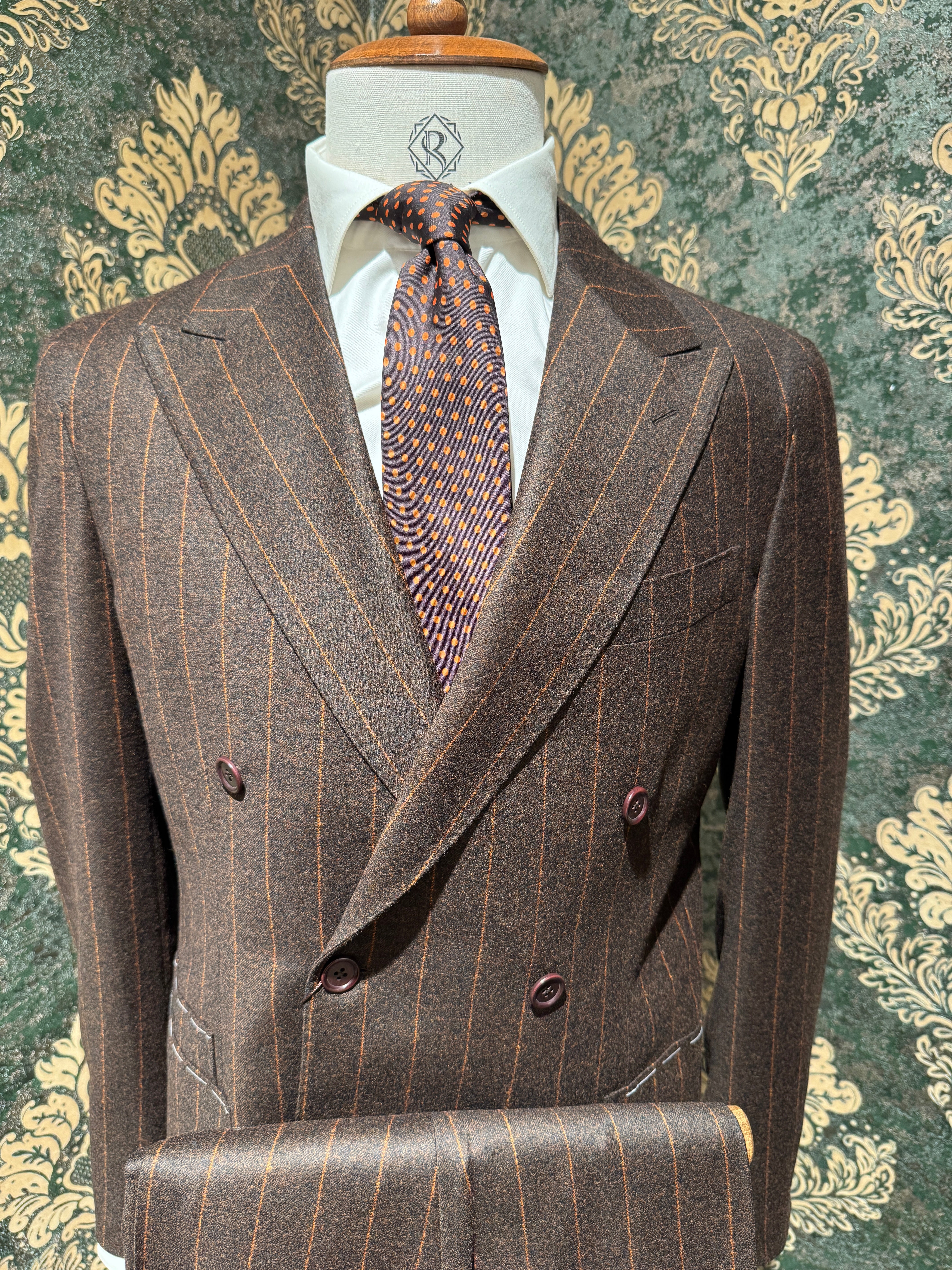 Zweireihiger brauner Nadelstreifenanzug mit orangefarbenen Streifen.