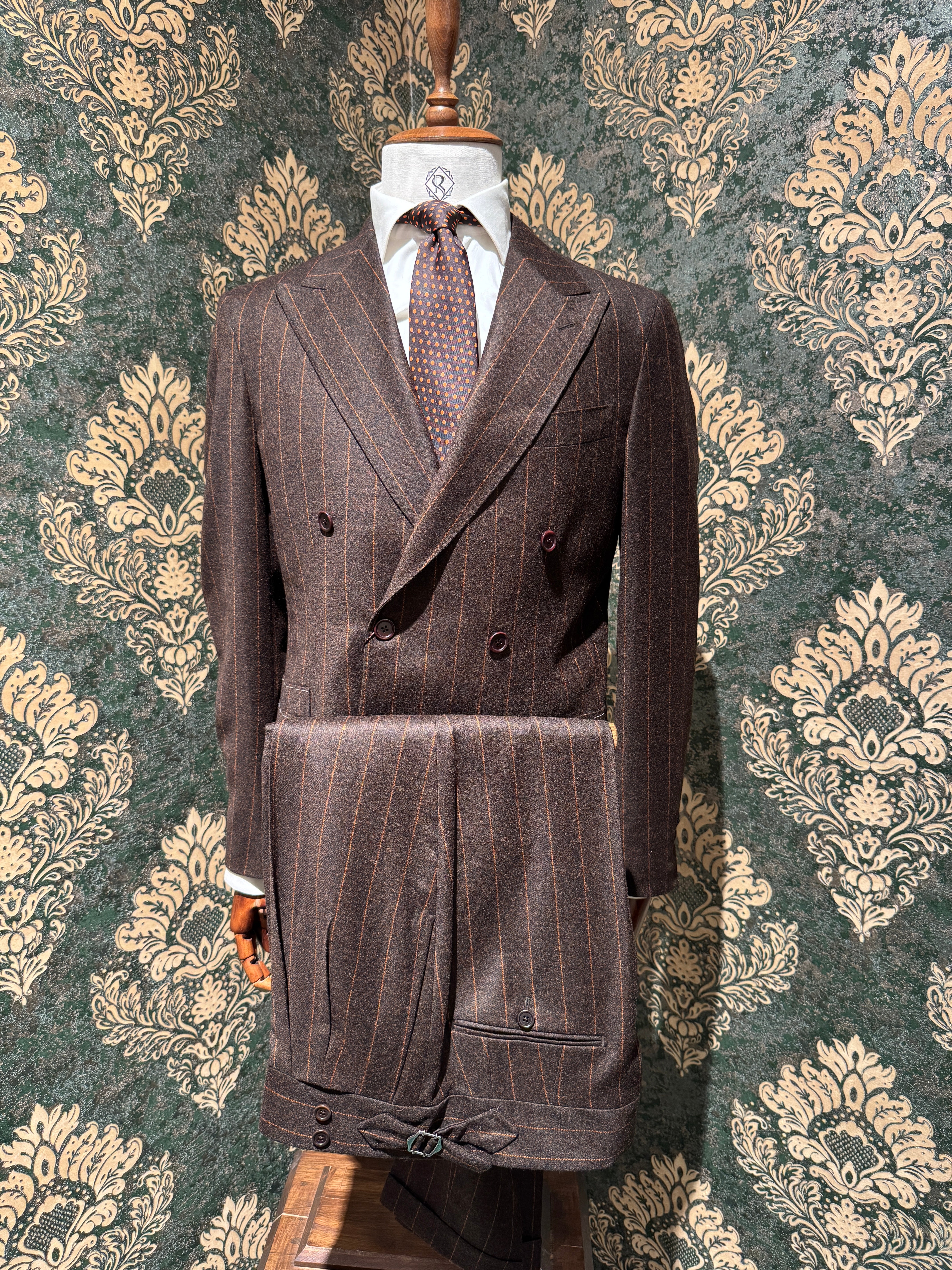 Zweireihiger brauner Nadelstreifenanzug mit orangefarbenen Streifen.