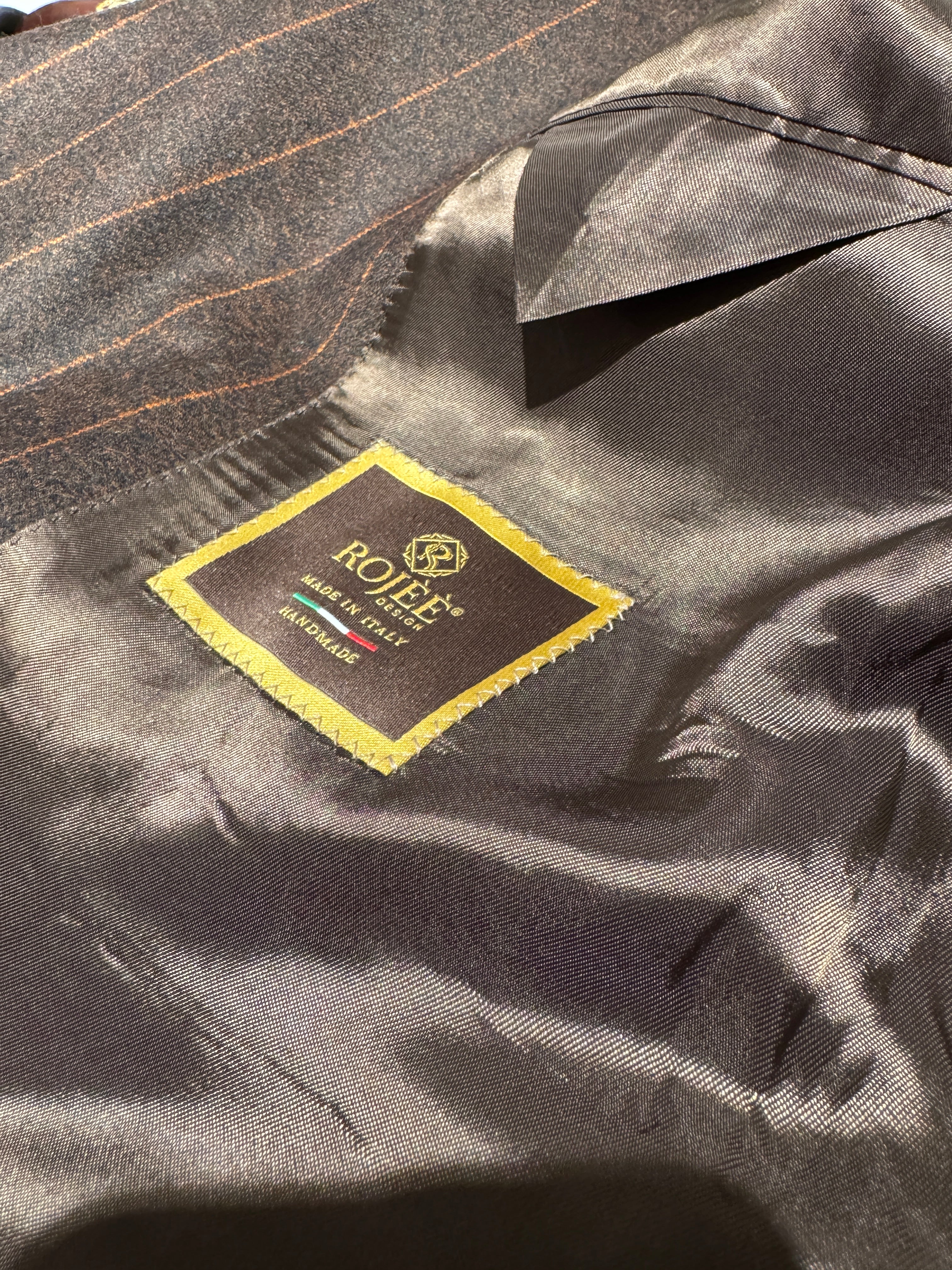 Zweireihiger brauner Nadelstreifenanzug mit orangefarbenen Streifen.